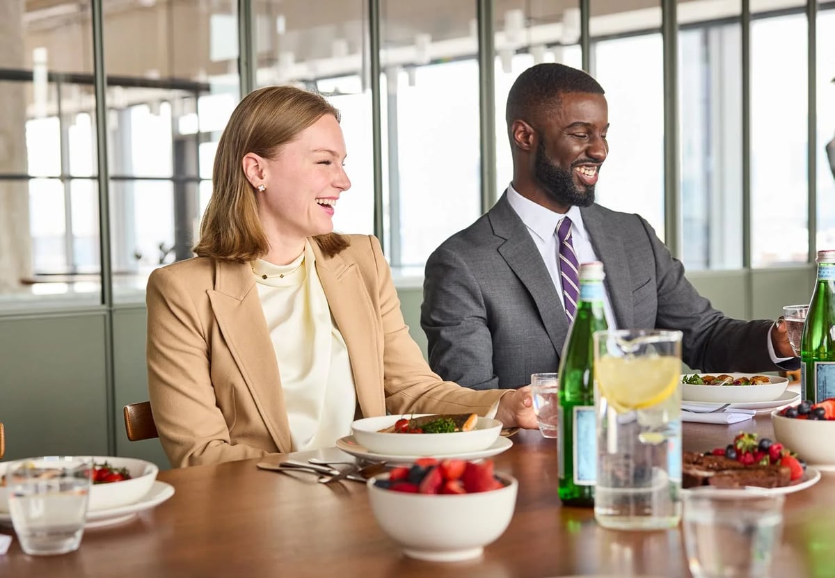 Colleagues eating a catered working lunch around a meeting table