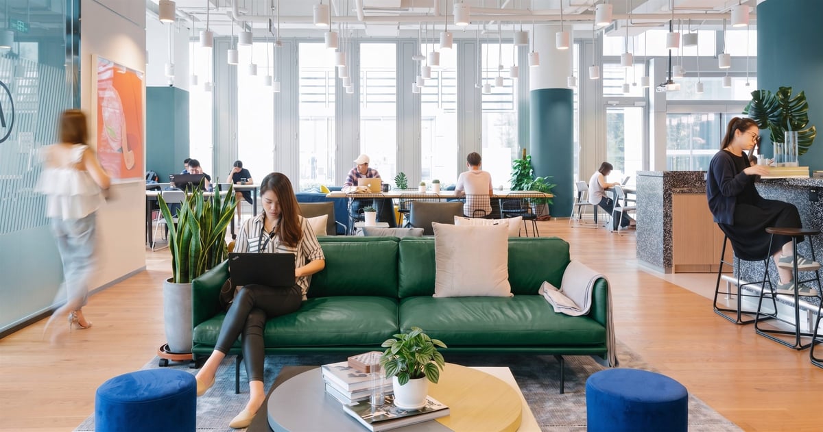 People working on laptops in a bright open-plan coworking office