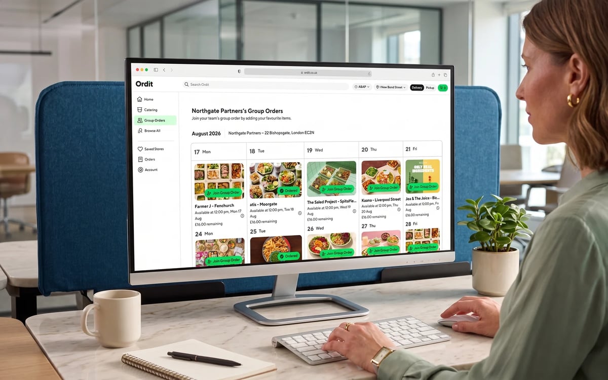 A woman at her desk viewing the Ordit ordering calendar on a monitor, each day showing a restaurant and the budget remaining